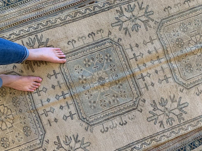 Woman's feet on a brown & grey Turkish oushak runner.