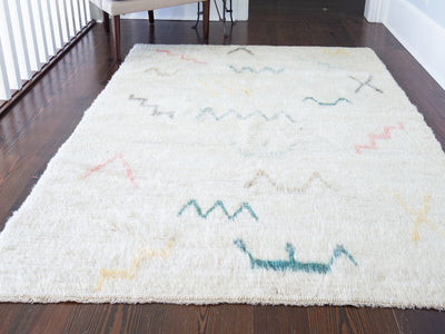 A modern white medium Turkish Tulu rug.